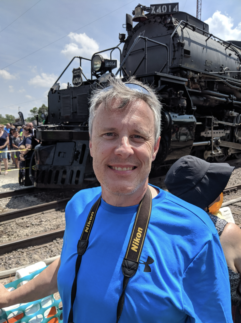 Erik Coleman standing in front of a train